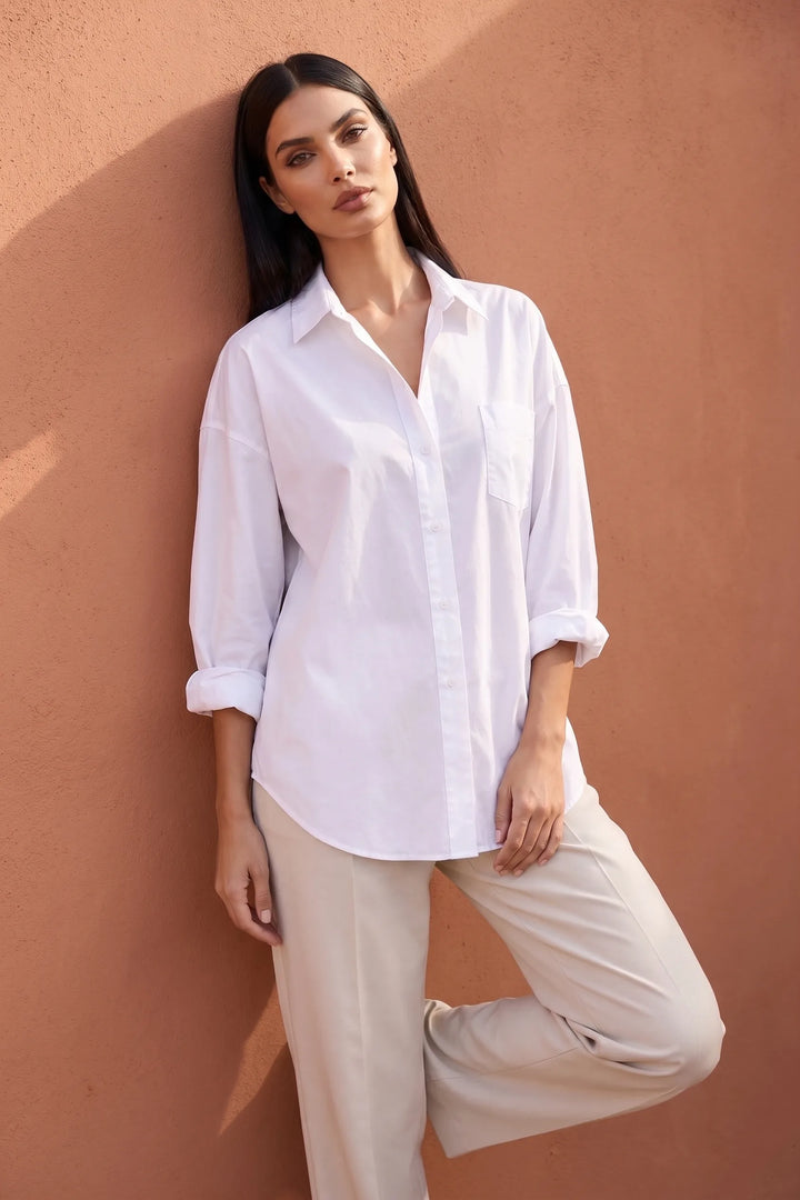 Model wearing white oversized button-down shirt in lifestyle setting