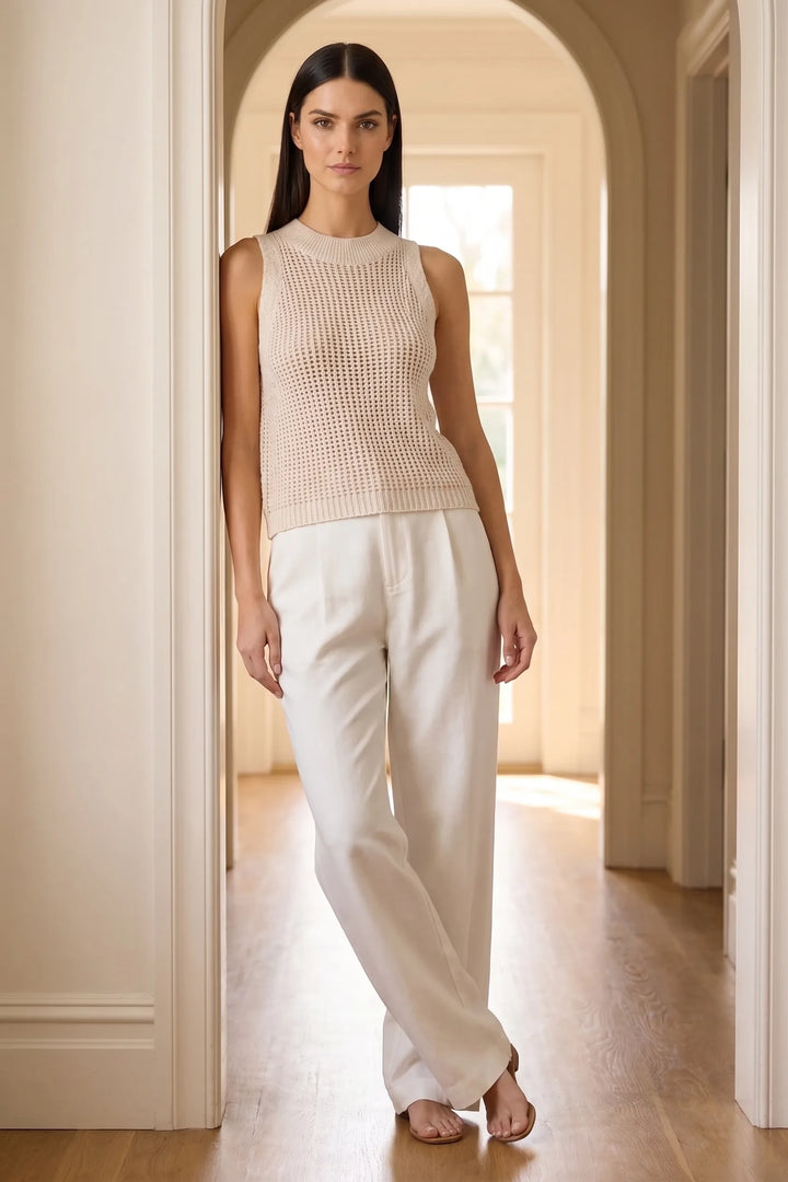 Model wearing apricot open knit tank top in a lifestyle setting