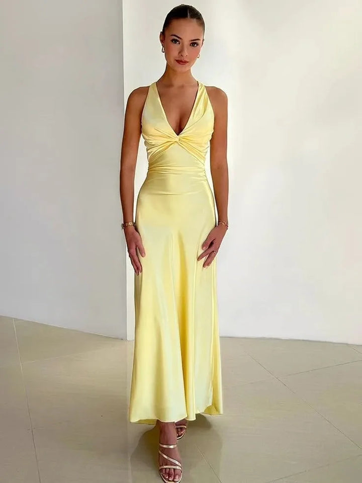 Yellow open-back bow gown on model facing forward, full-length view