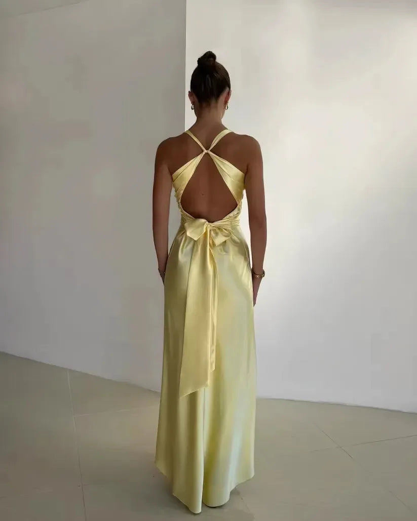 Yellow open-back bow gown on model in three-quarter turn, showing back detail