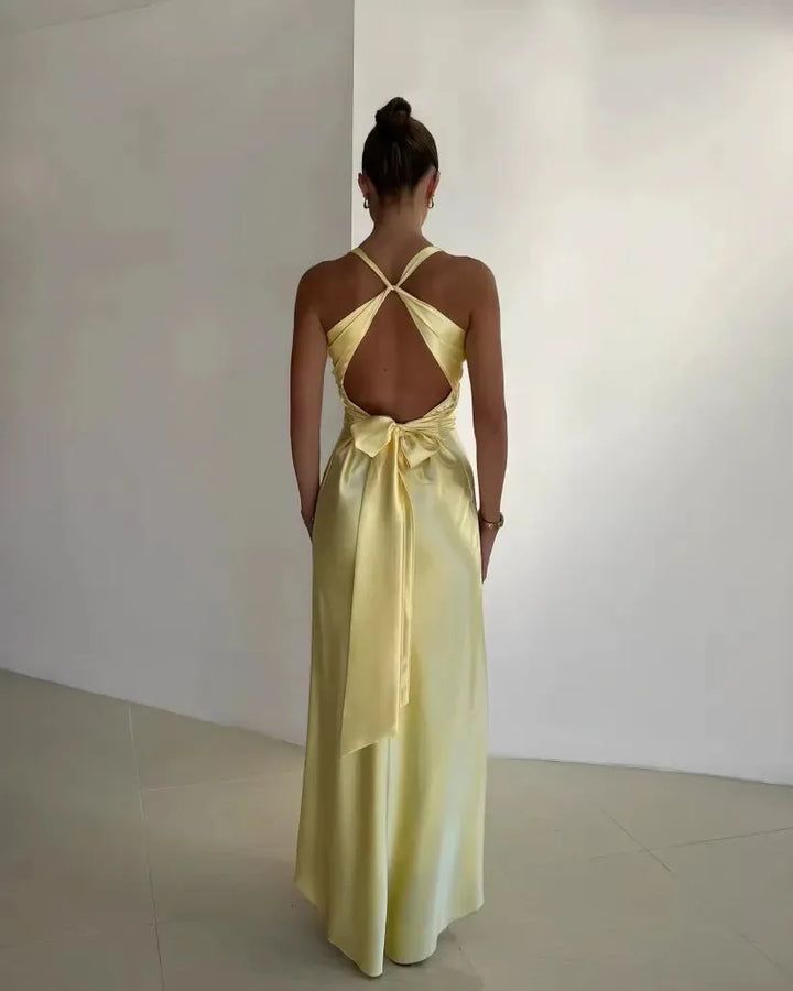 Yellow open-back bow gown on model in three-quarter turn, showing back detail