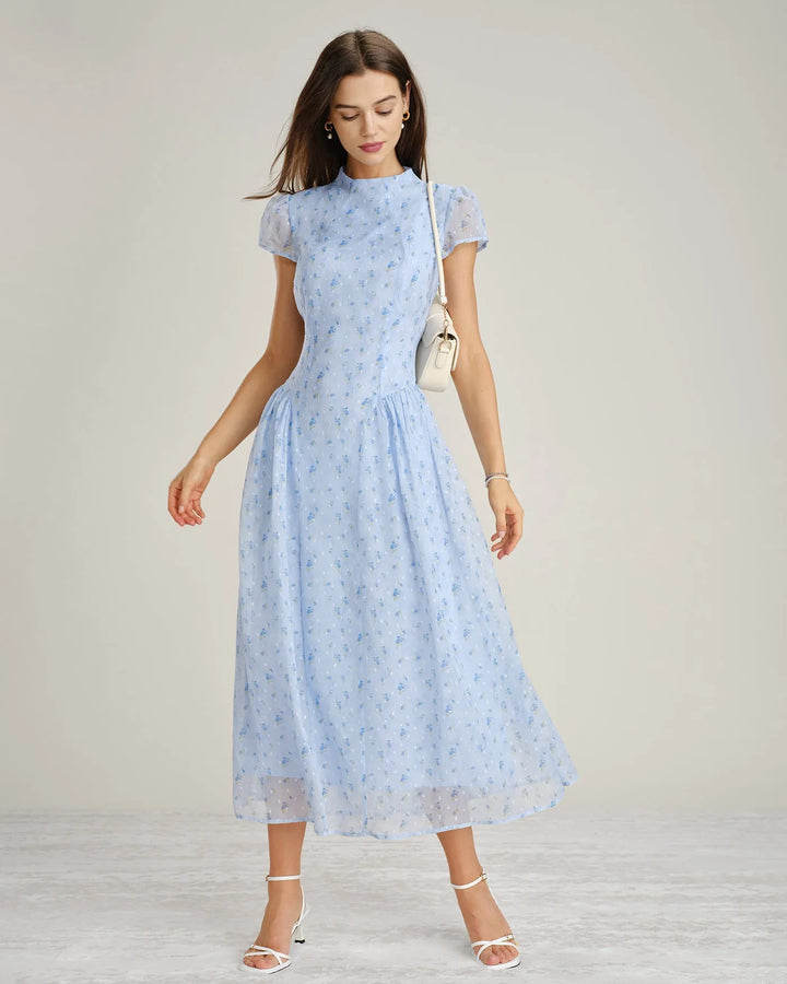 Model facing forward in a blue chiffon drop waist midi dress