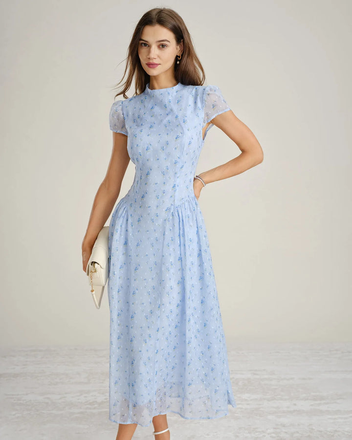 Side view of model wearing a blue chiffon drop waist midi dress