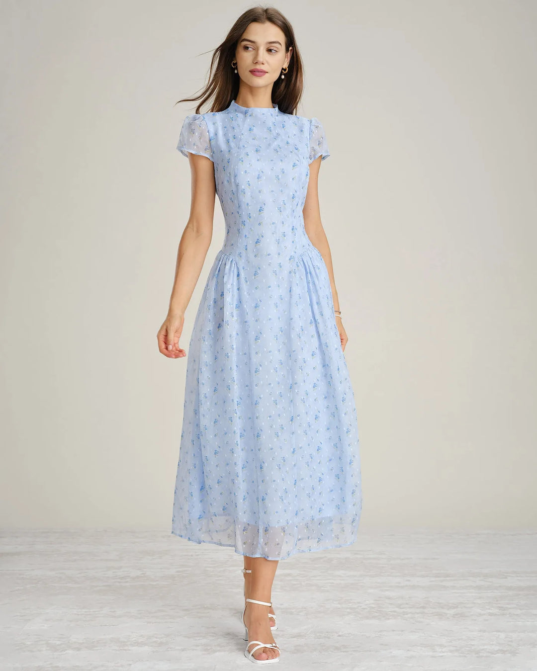 Model in a three-quarter turn wearing a blue chiffon drop waist midi dress