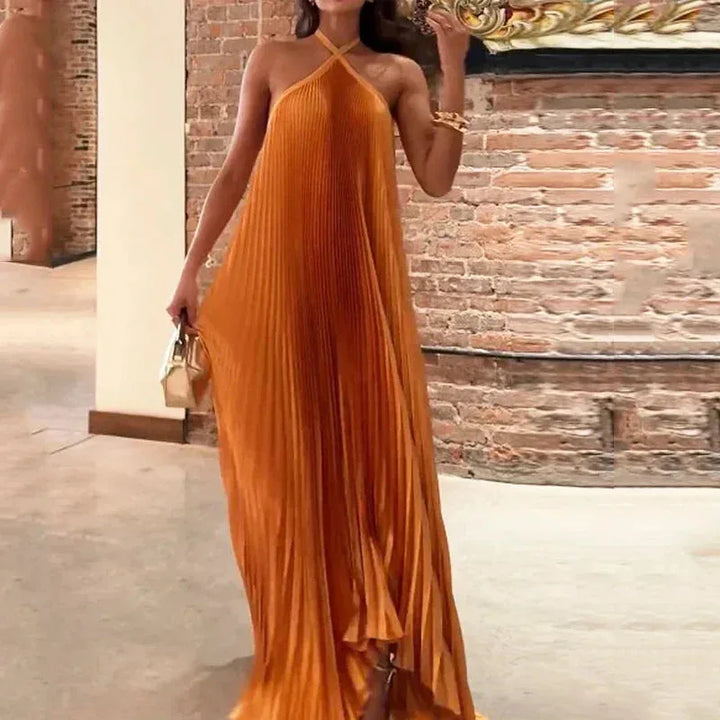 Orange pleated halter maxi dress on model in three-quarter turn pose