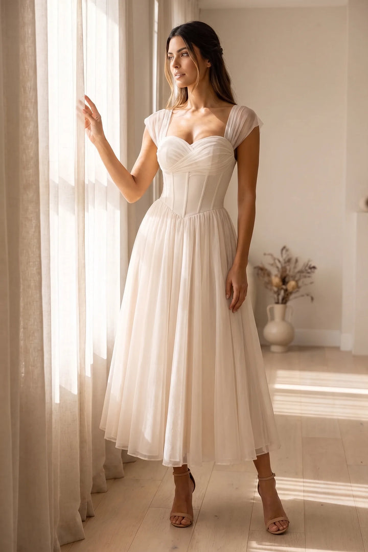 Model wearing apricot corset tulle midi dress in lifestyle setting