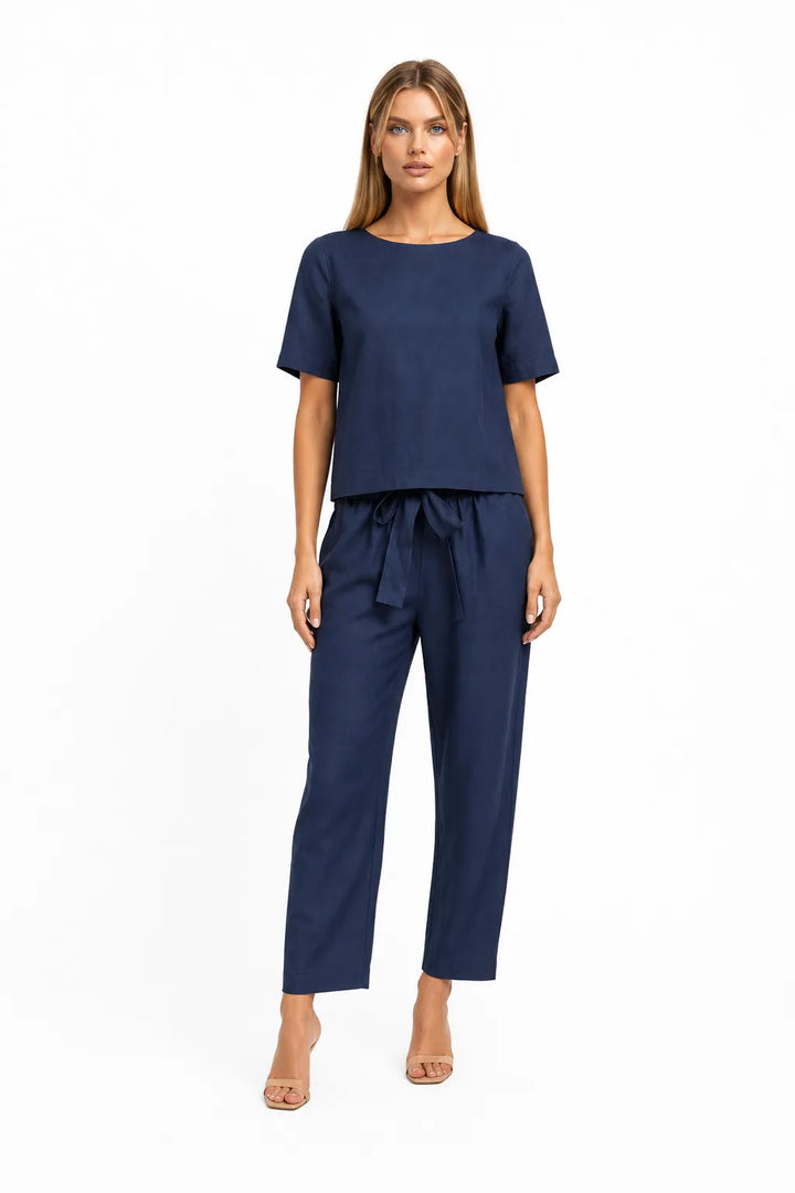 Blue linen crop top on model in relaxed contrapposto stance