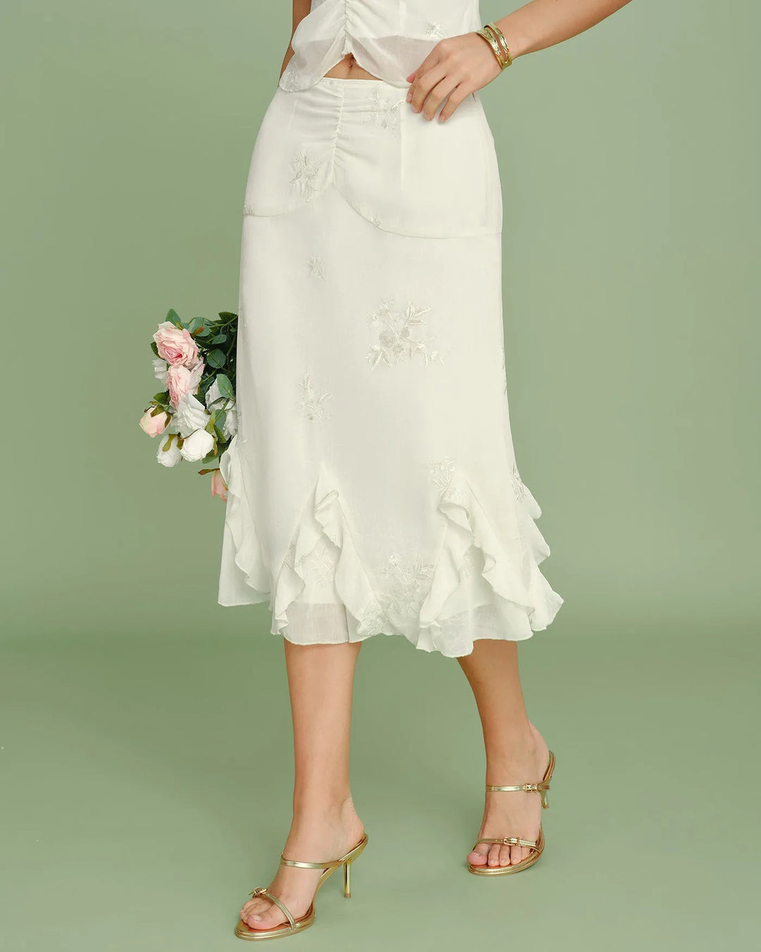 Close-up detail of ruching and embroidery on apricot midi skirt