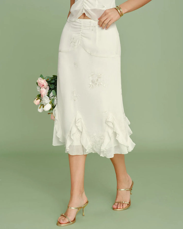 Close-up detail of ruching and embroidery on apricot midi skirt