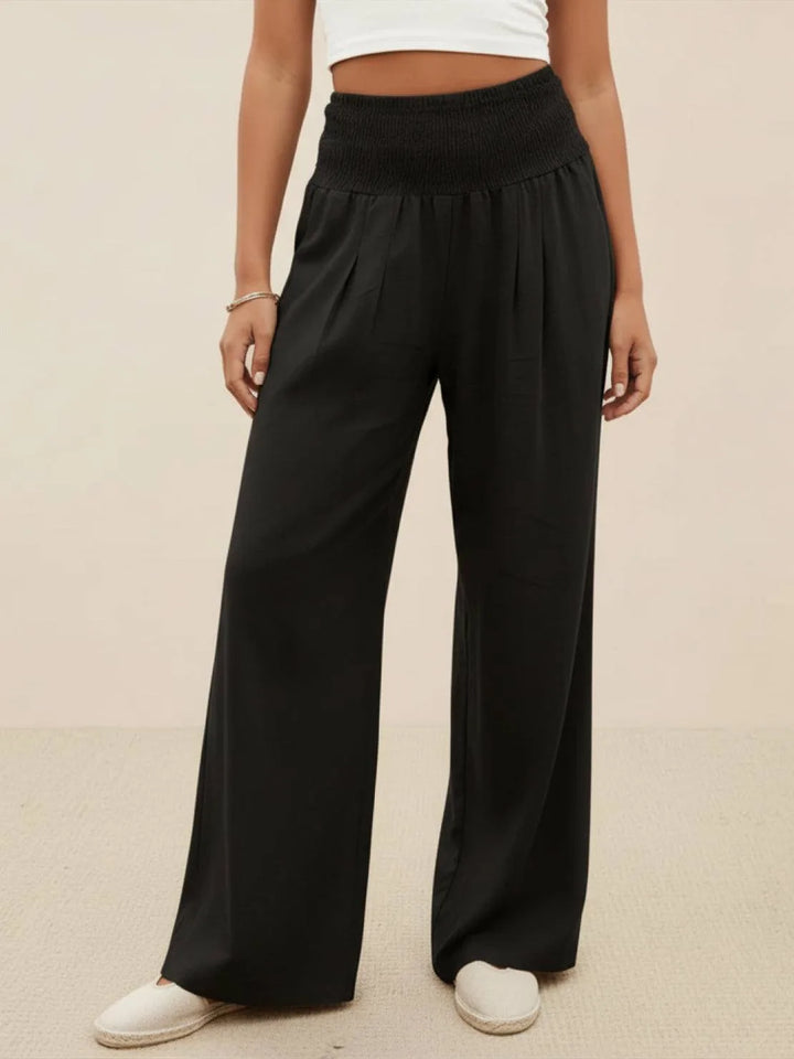 Black smocked wide leg pants on model, full-length view