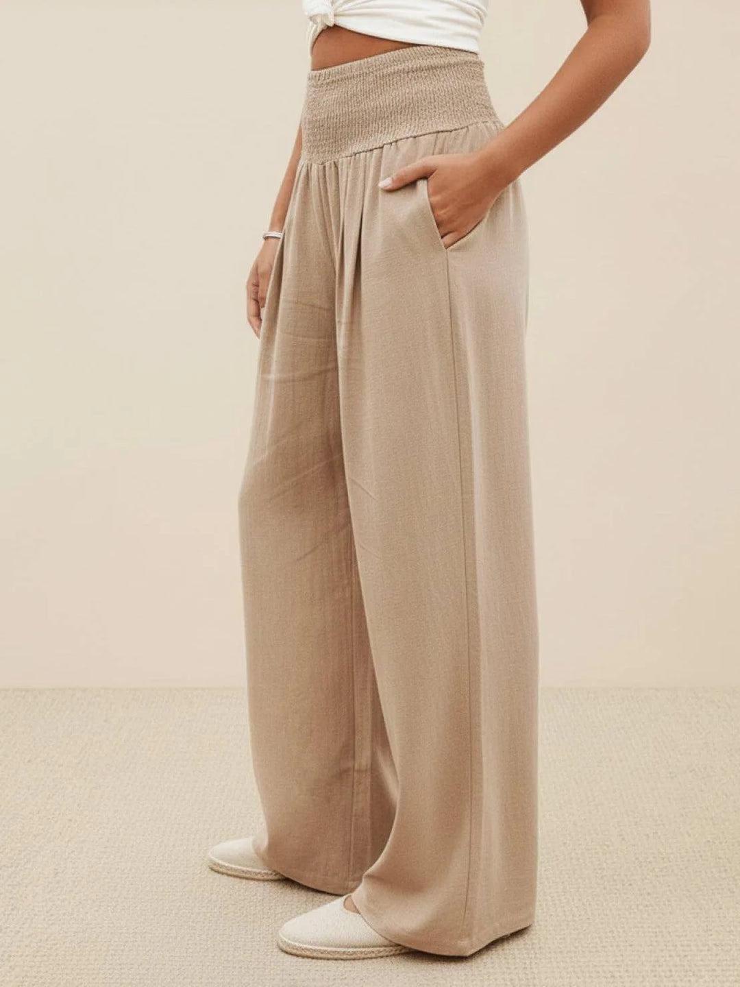 Khaki smocked wide leg pants on model, three-quarter turn