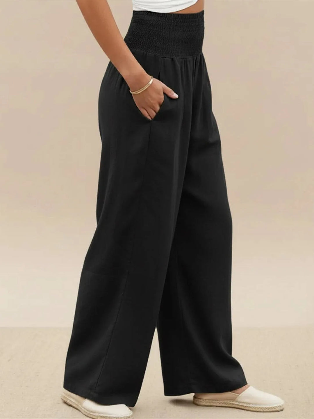 Khaki smocked wide leg pants on model, styled standing view