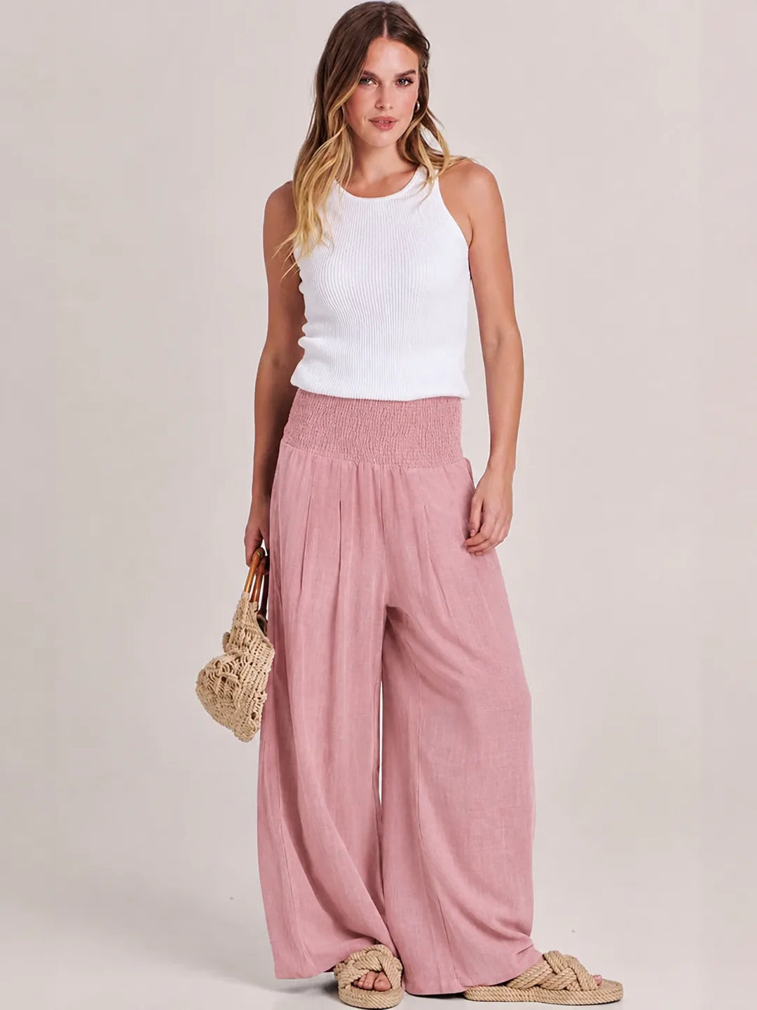 Khaki smocked wide leg pants on model, standing angled pose