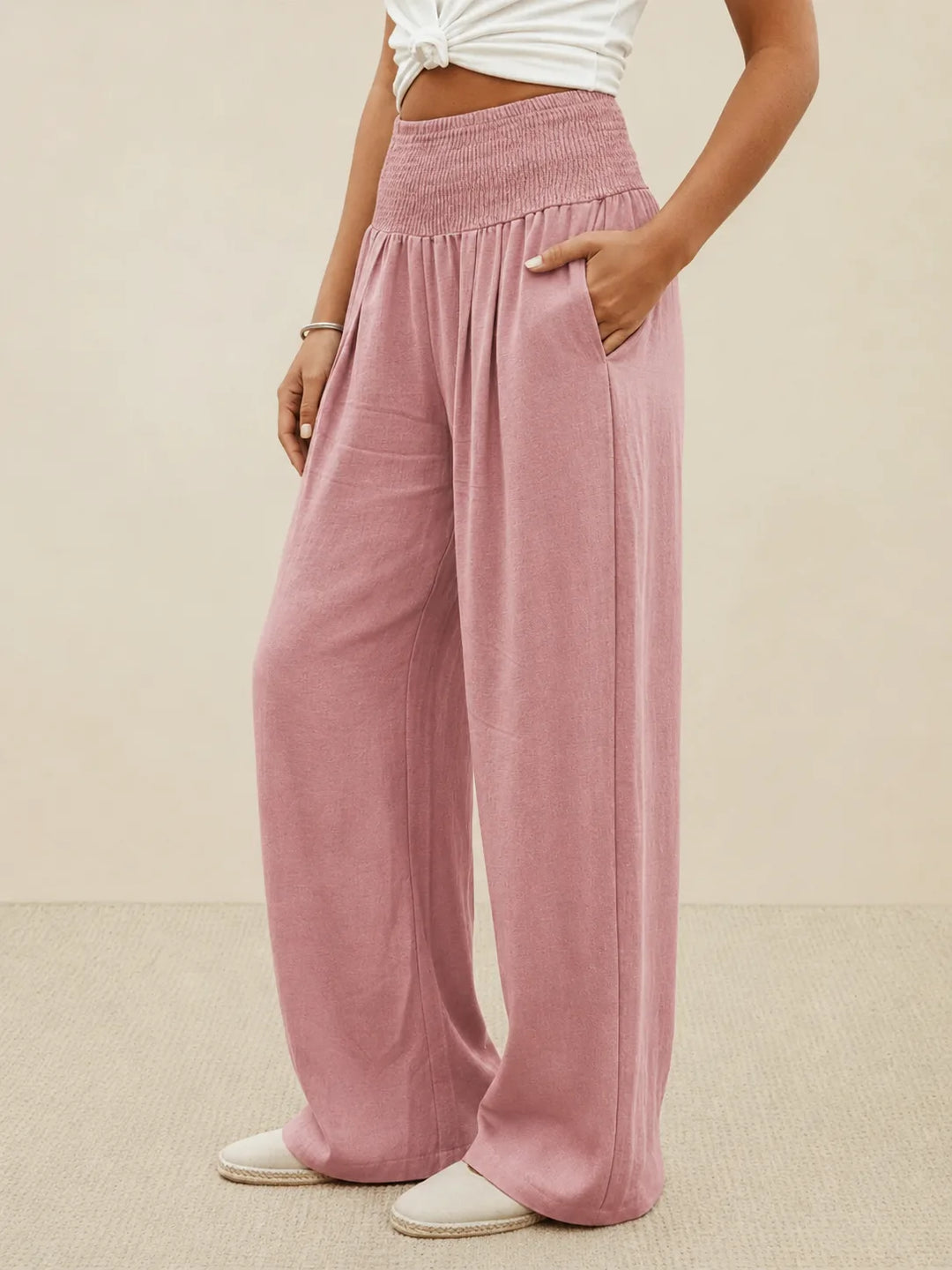 Khaki smocked wide leg pants on model, close full-length view
