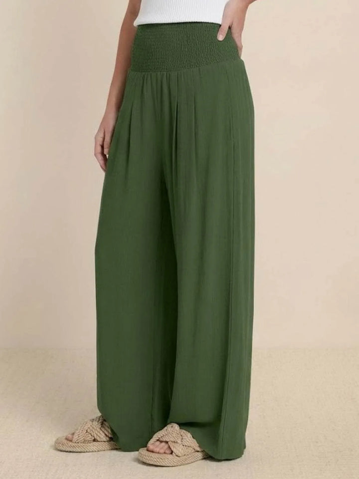 Khaki smocked wide leg pants on model, relaxed standing pose