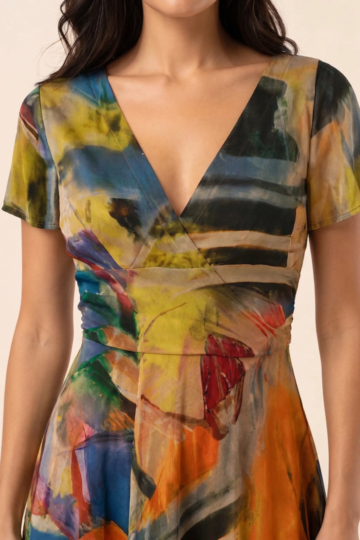 Close-up detail of orange abstract print midi dress fabric and pattern