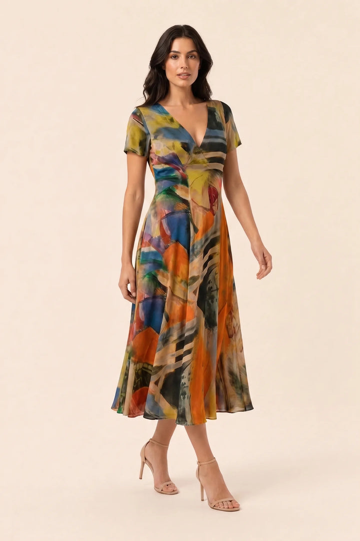 Orange abstract print midi dress on model in three-quarter turn