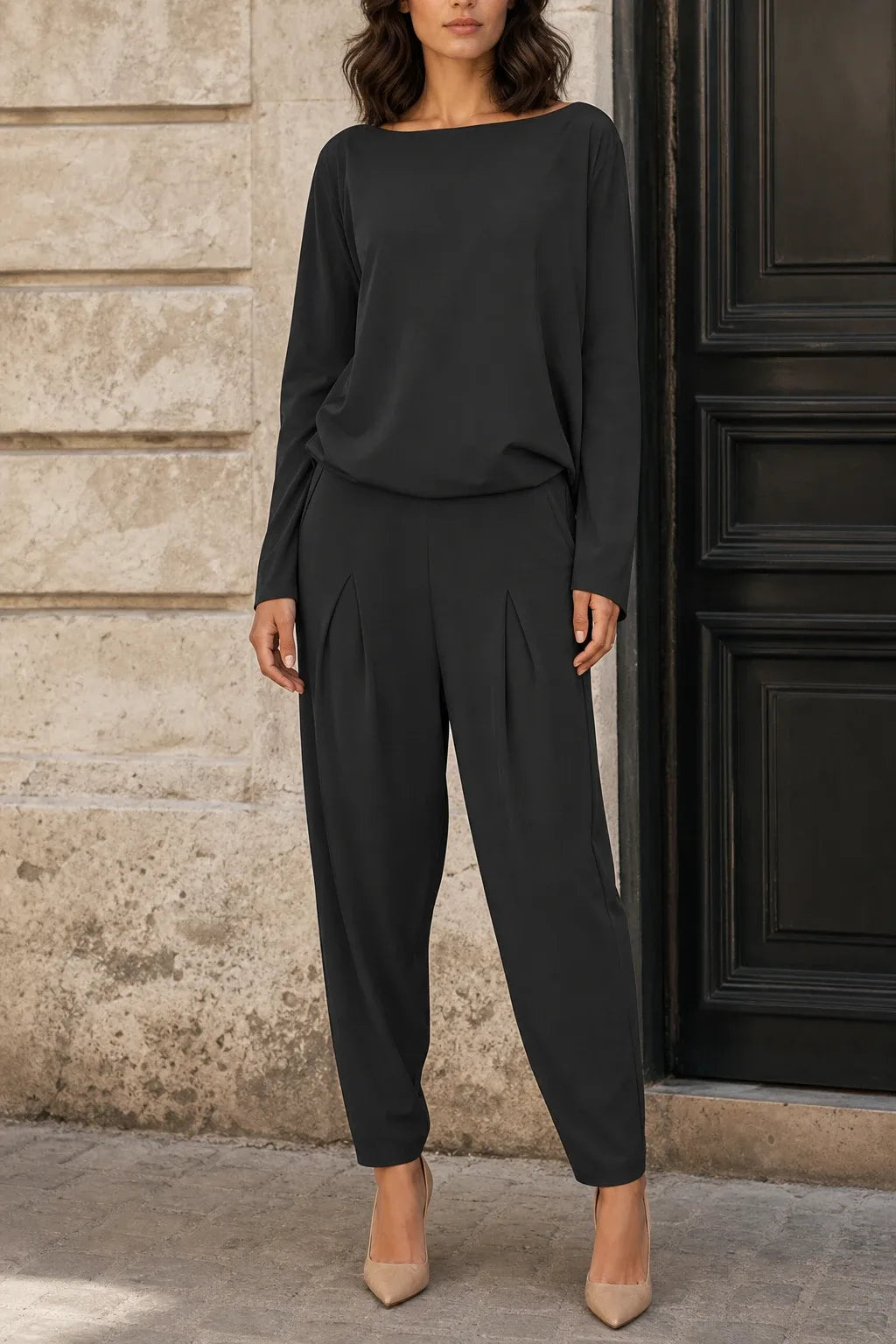 Black bateau neck knit trouser set on model in contrapposto stance