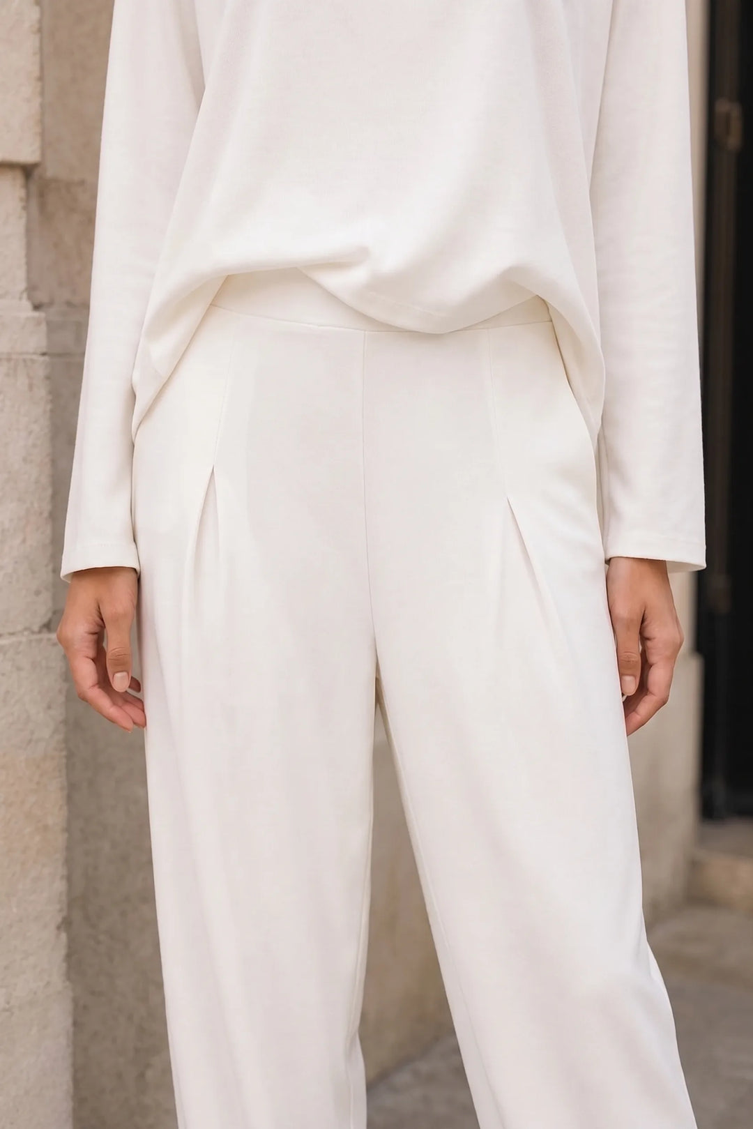 Close-up detail of off-white bateau neck knit trouser set fabric and fit