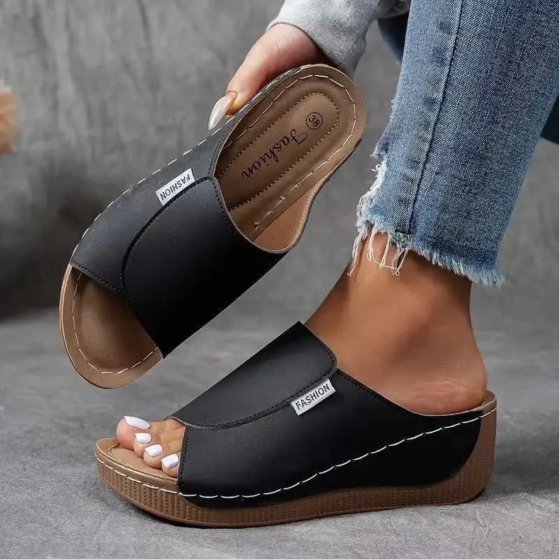 Black wedge platform mule, three-quarter view showing structure and platform detail