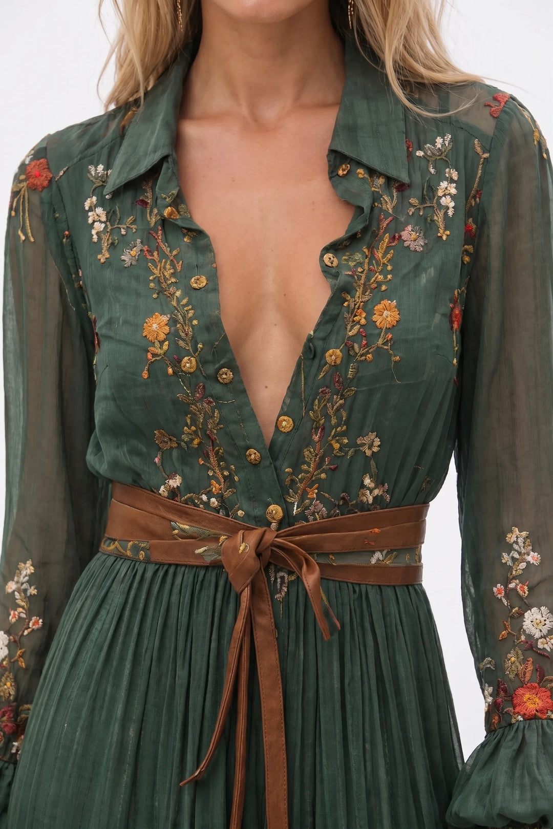 Close-up detail of green embroidered boho maxi dress fabric and stitching