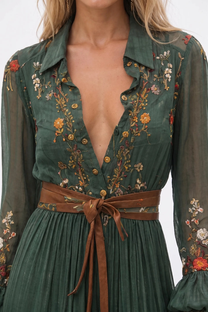 Close-up detail of green embroidered boho maxi dress fabric and stitching