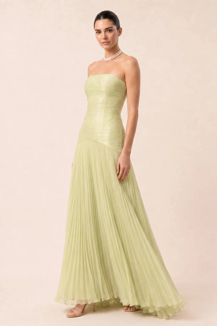 Emerald green pleated drop waist gown on a model in a three-quarter turn