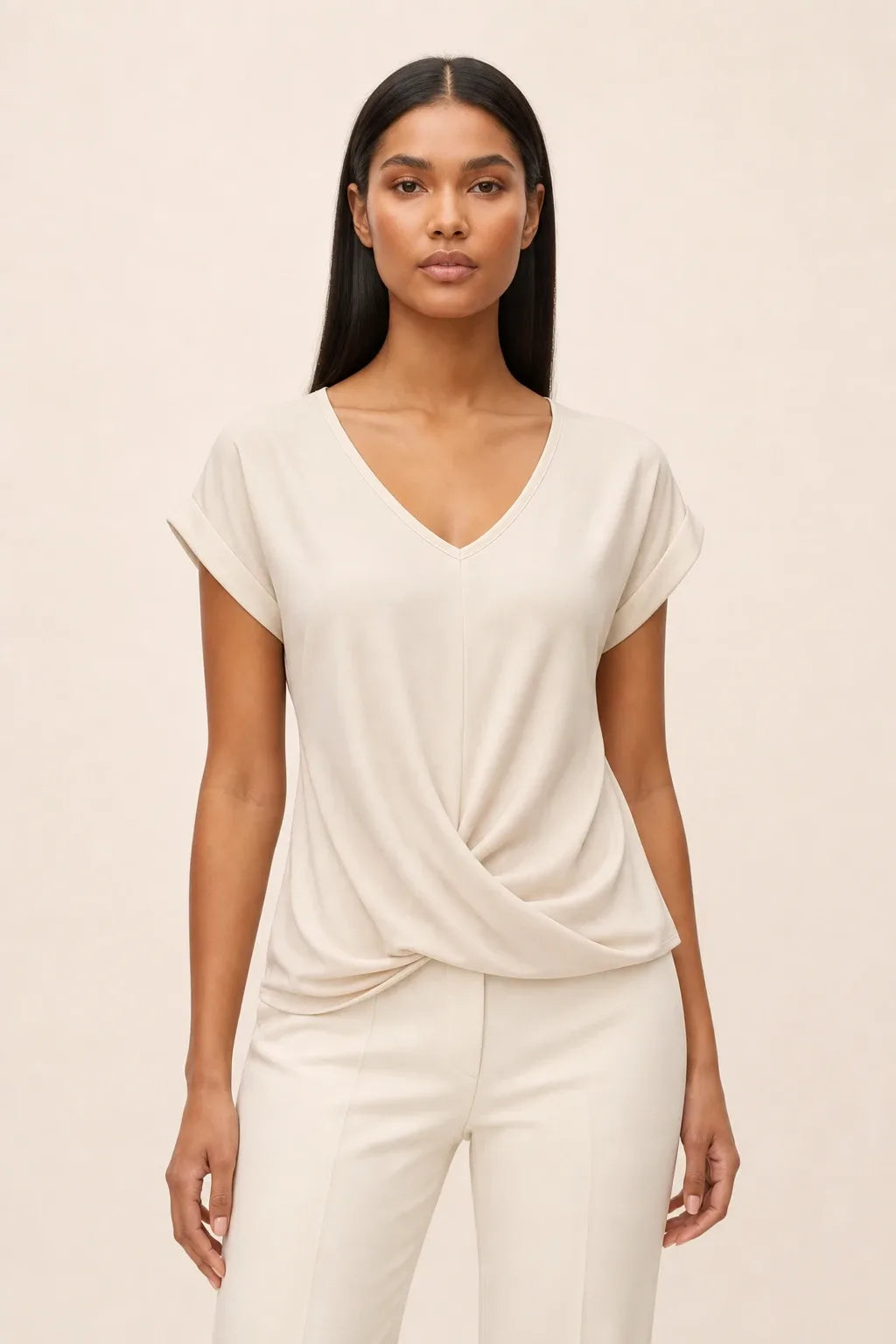Apricot twist-front cap sleeve top on a model in a contrapposto stance