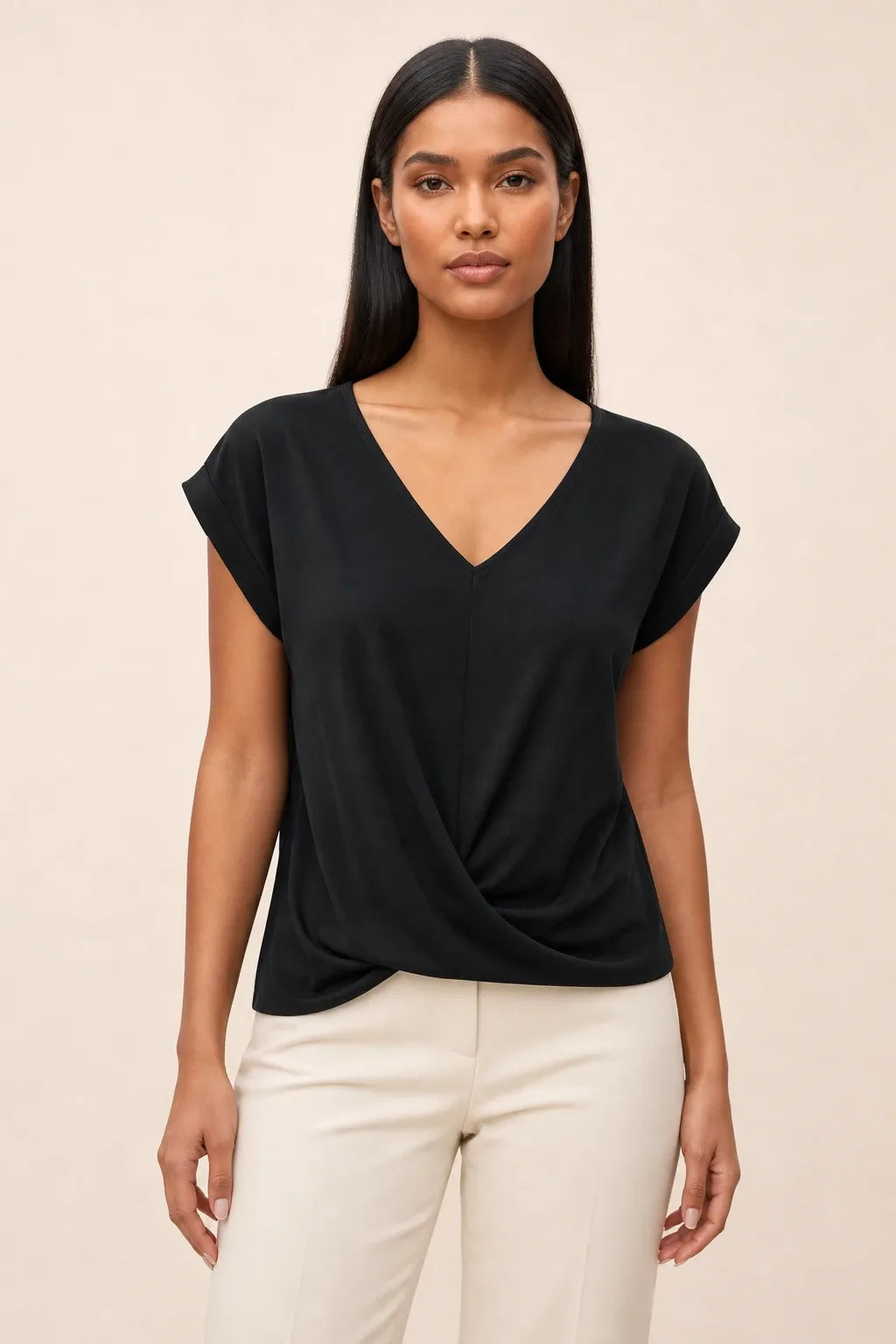 Black twist-front cap sleeve top on a model in a contrapposto stance
