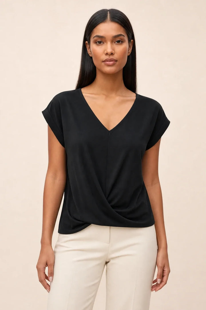 Black twist-front cap sleeve top on a model in a contrapposto stance