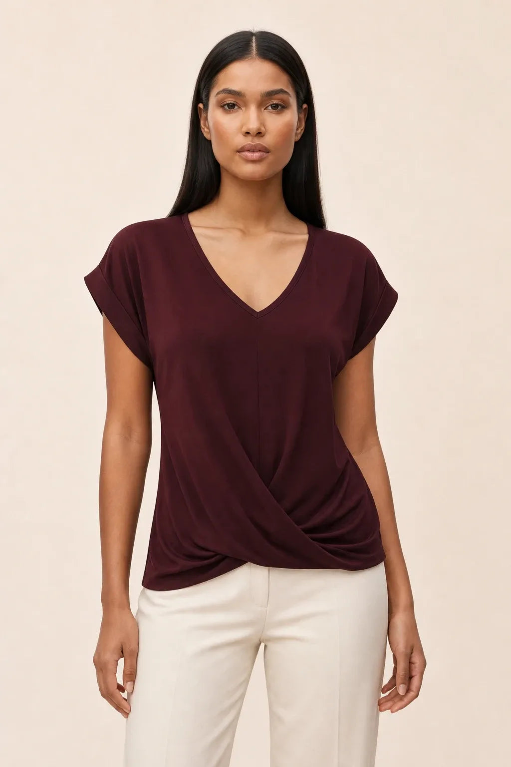 Burgundy twist-front cap sleeve top on a model in a contrapposto stance