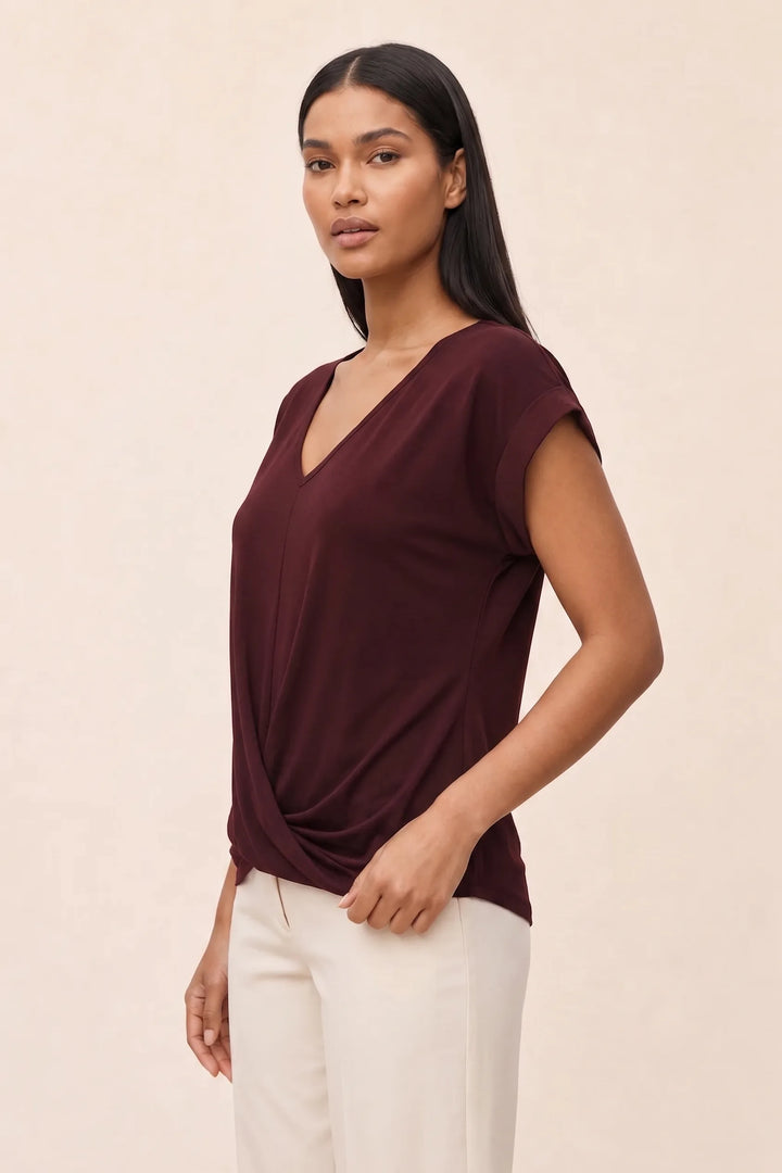 Burgundy twist-front cap sleeve top on a model in a three-quarter turn