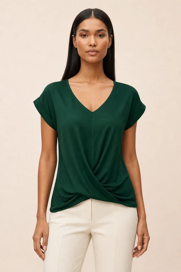 Green twist-front cap sleeve top on a model in a contrapposto stance