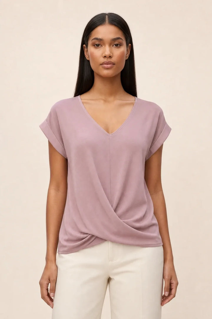 Pink twist-front cap sleeve top on a model in a contrapposto stance