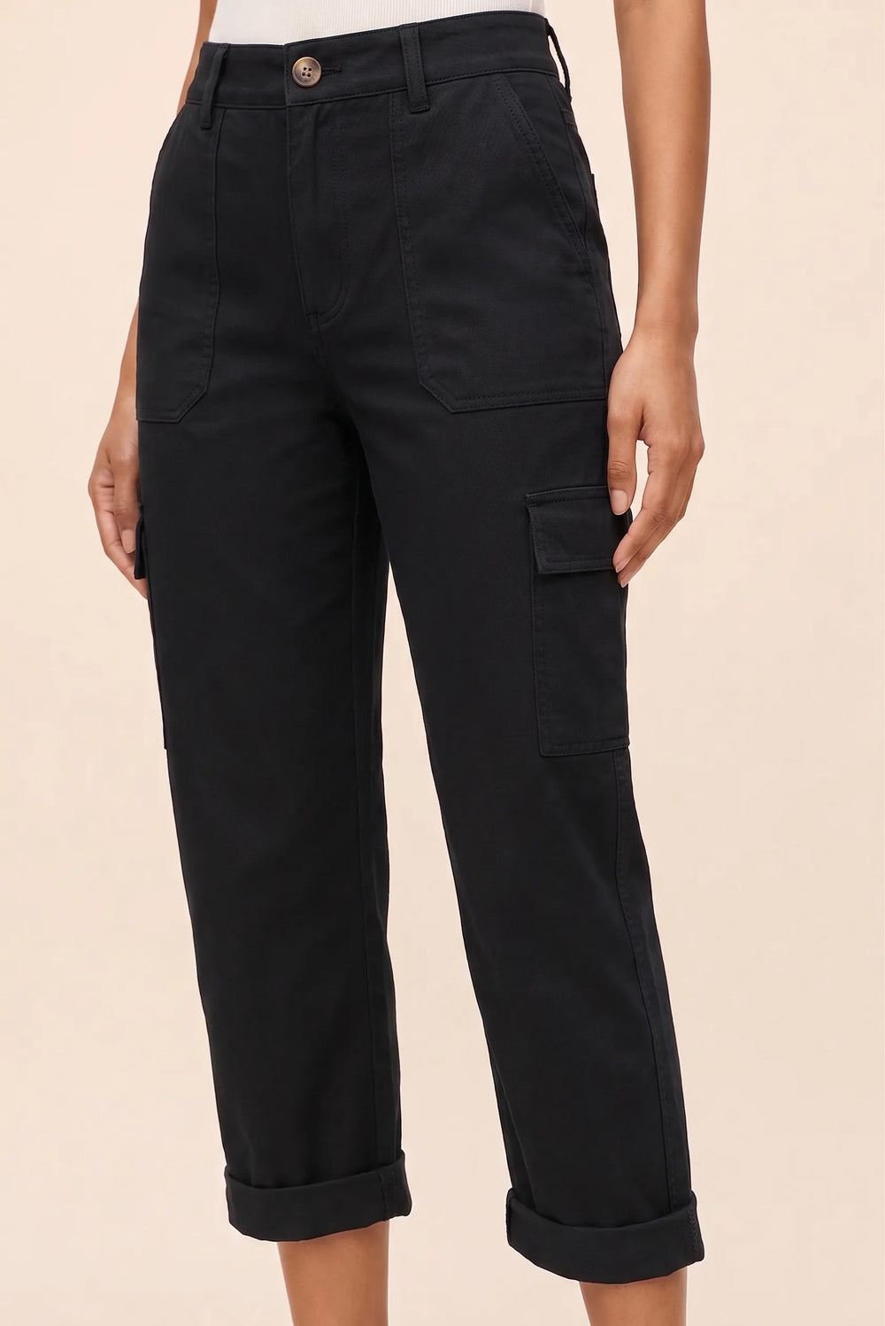 Close-up detail of black cargo capri pants highlighting pocket and fabric texture