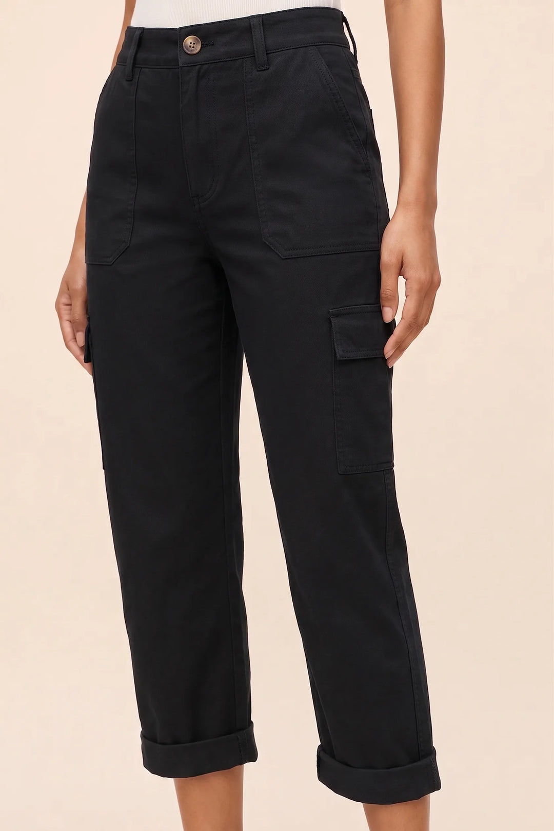 Close-up detail of black cargo capri pants highlighting pocket and fabric texture