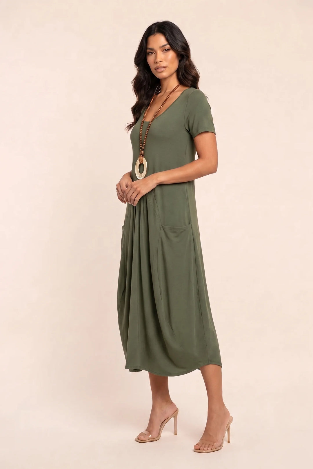 Green flowy midi dress with pockets on model in three-quarter turn