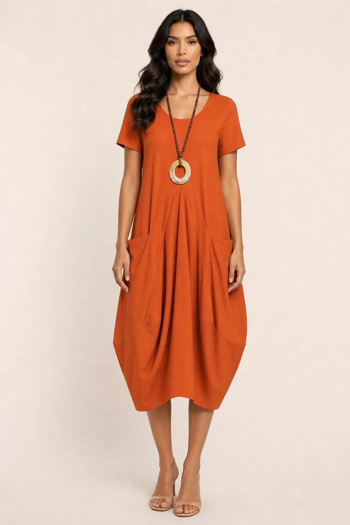 Orange flowy midi dress with pockets on model in contrapposto stance