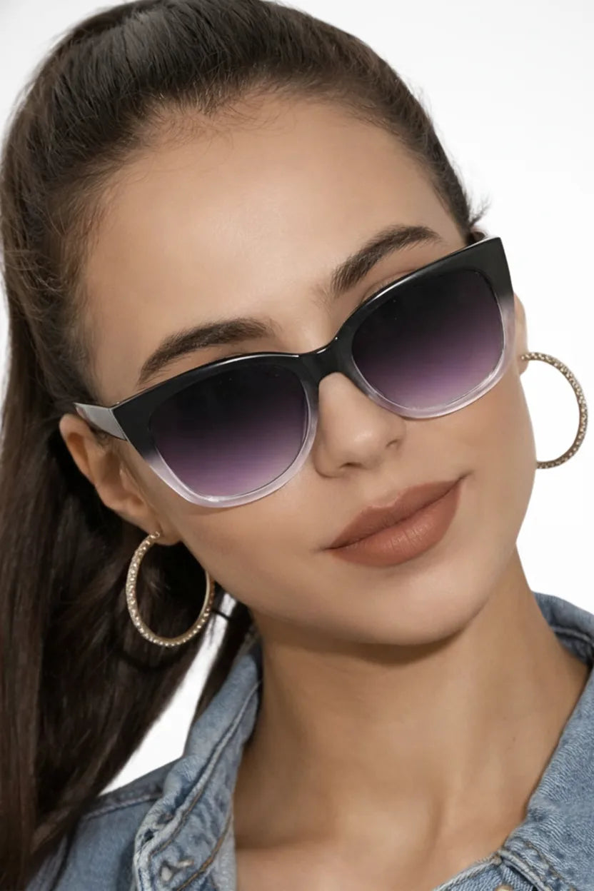 Oversized two-tone black cat eye sunglasses displayed flat on white background