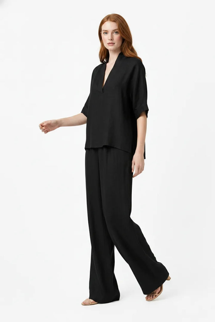 Black linen kimono jacket and wide-leg trousers on a model in natural movement