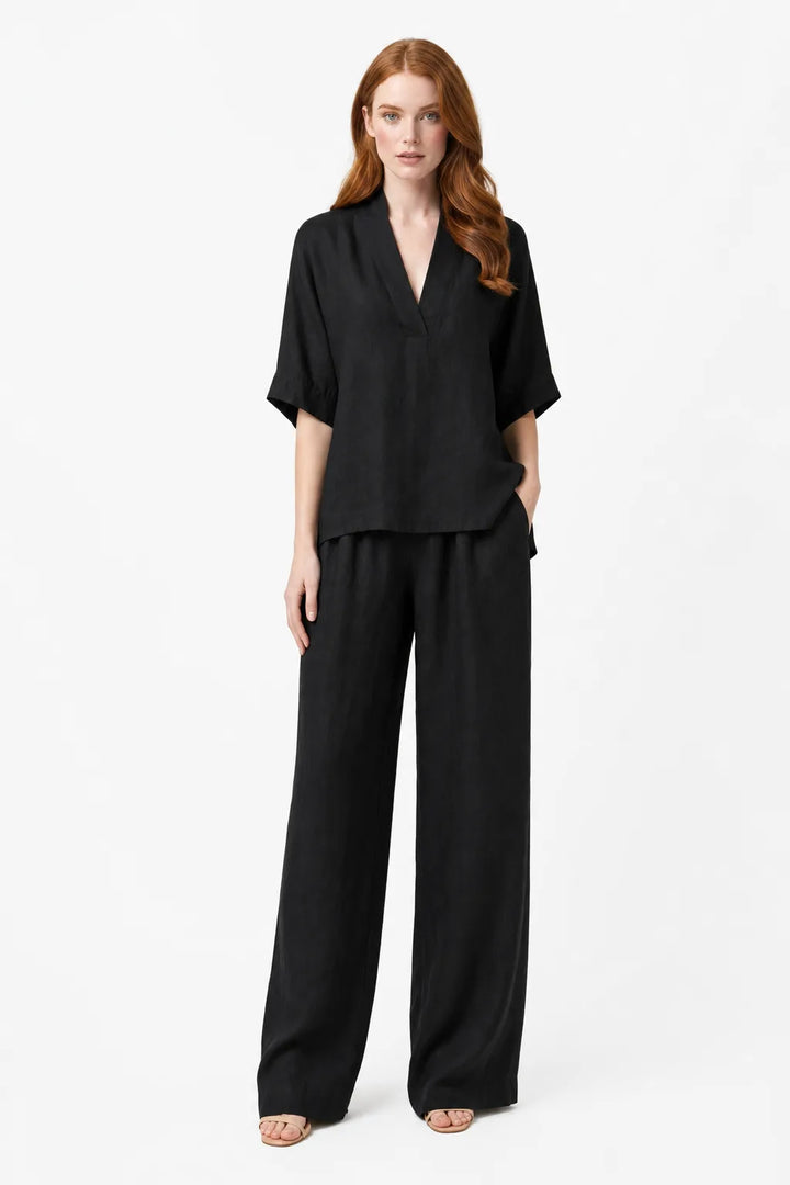 Black linen kimono jacket and wide-leg trousers on a model in a contrapposto stance
