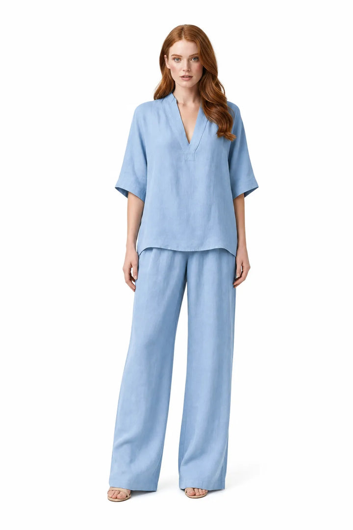 Blue linen kimono jacket and wide-leg trousers on a model in a contrapposto stance