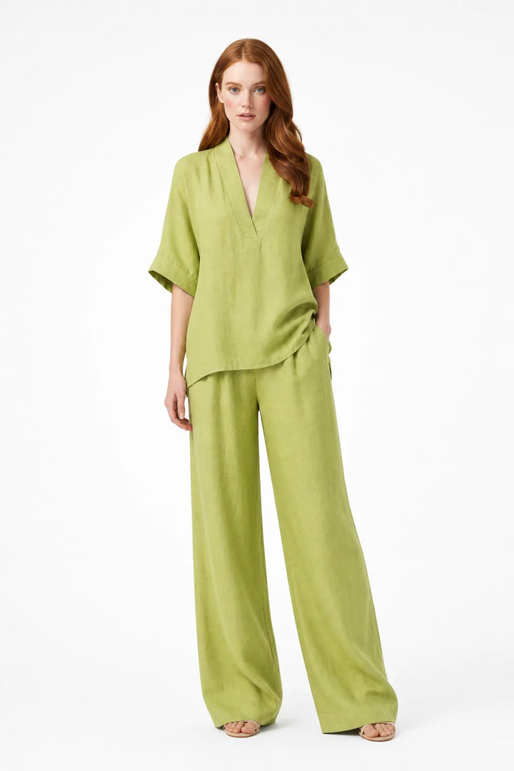 Green linen kimono jacket and wide-leg trousers on a model in a contrapposto stance