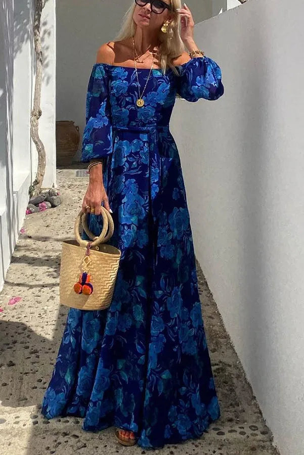 Woman wearing a blue floral off-shoulder maxi dress, turned three-quarters