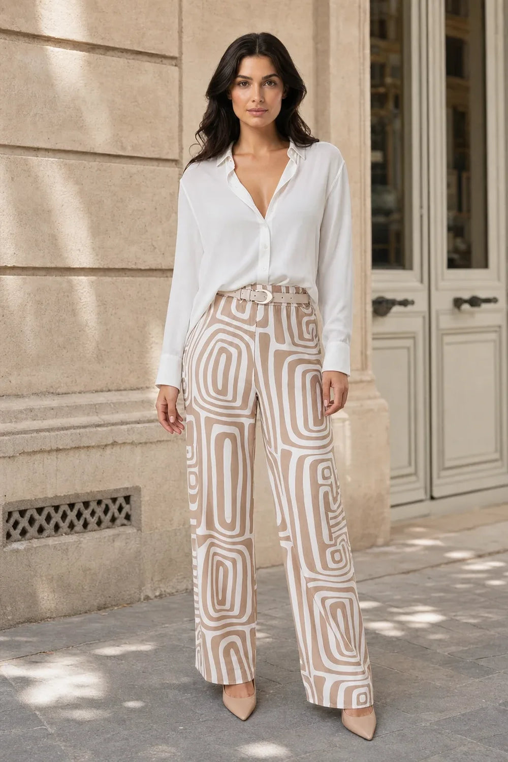 Woman in khaki geo print matching trouser set standing in a contrapposto pose