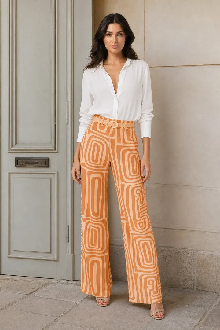 Woman in orange geo print matching trouser set standing in a contrapposto pose