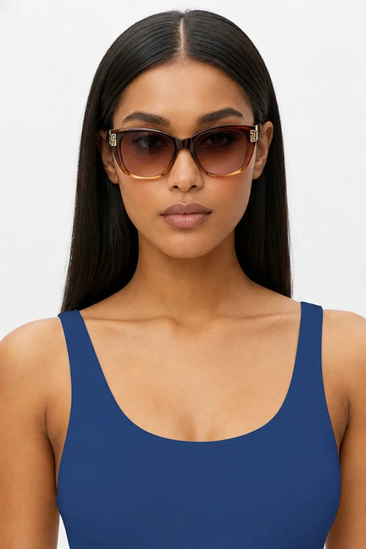 Woman wearing oversized square cat-eye sunglasses in blue, front-facing close-up