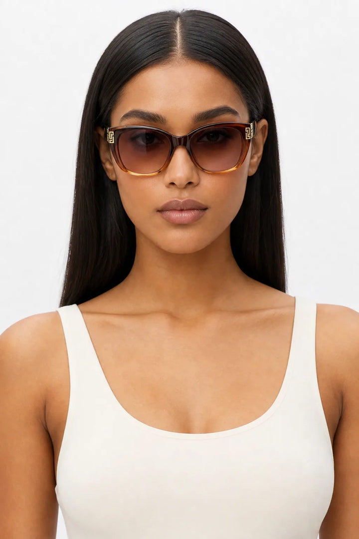Woman wearing oversized square cat-eye sunglasses in brown gradient, front-facing close-up