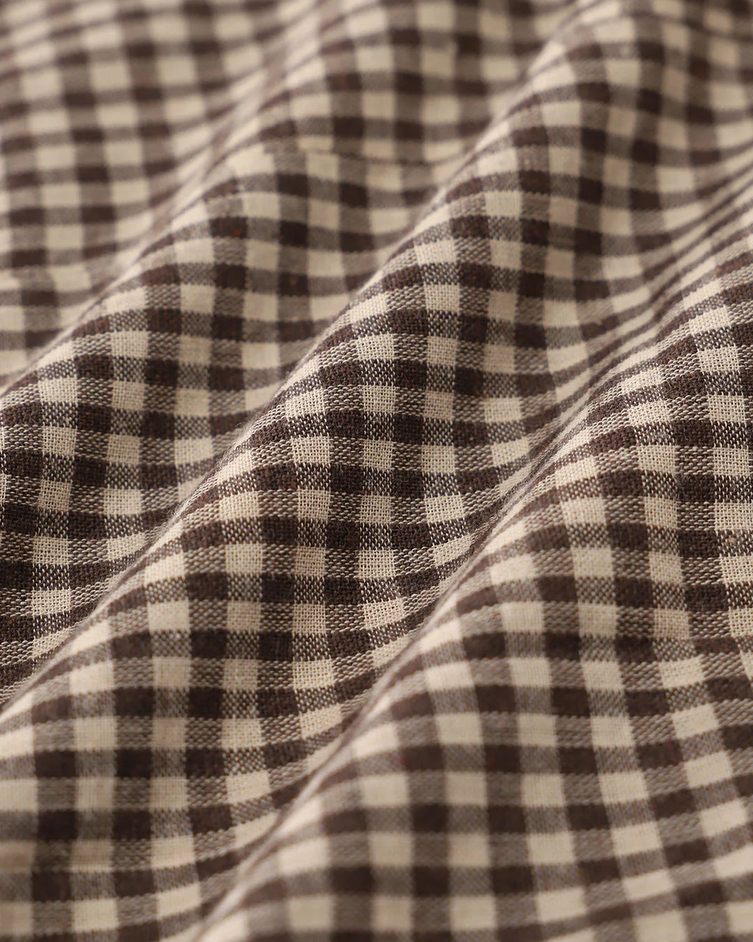 Alternative view of a woman wearing a brown lace-trimmed gingham top