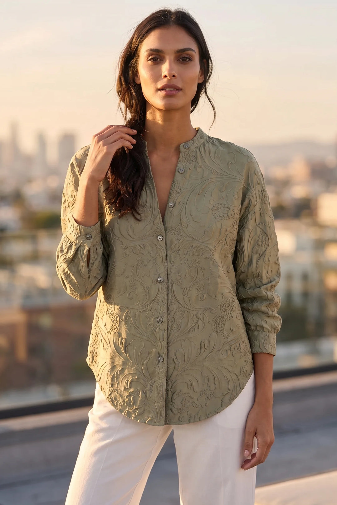 Model wearing green embossed floral blouse in a lifestyle setting